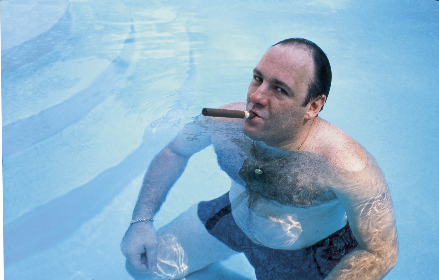 American actor James Gandolfini, as Tony Soprano, smokes a cigar while he stands in pool, in publicity still for the HBO cable TV series 'The Sopranos,' 1999.