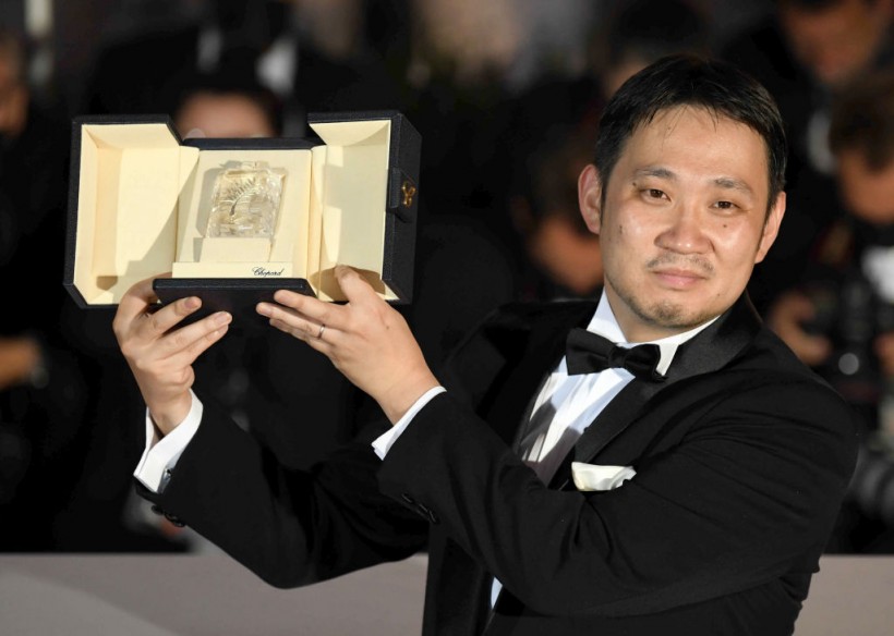 Ryusuke Hamaguchi poses with the 'Best Screenplay Award' for 'Drive my Car' during the 74th annual Cannes Film Festival on July 17, 2021 in Cannes, France.