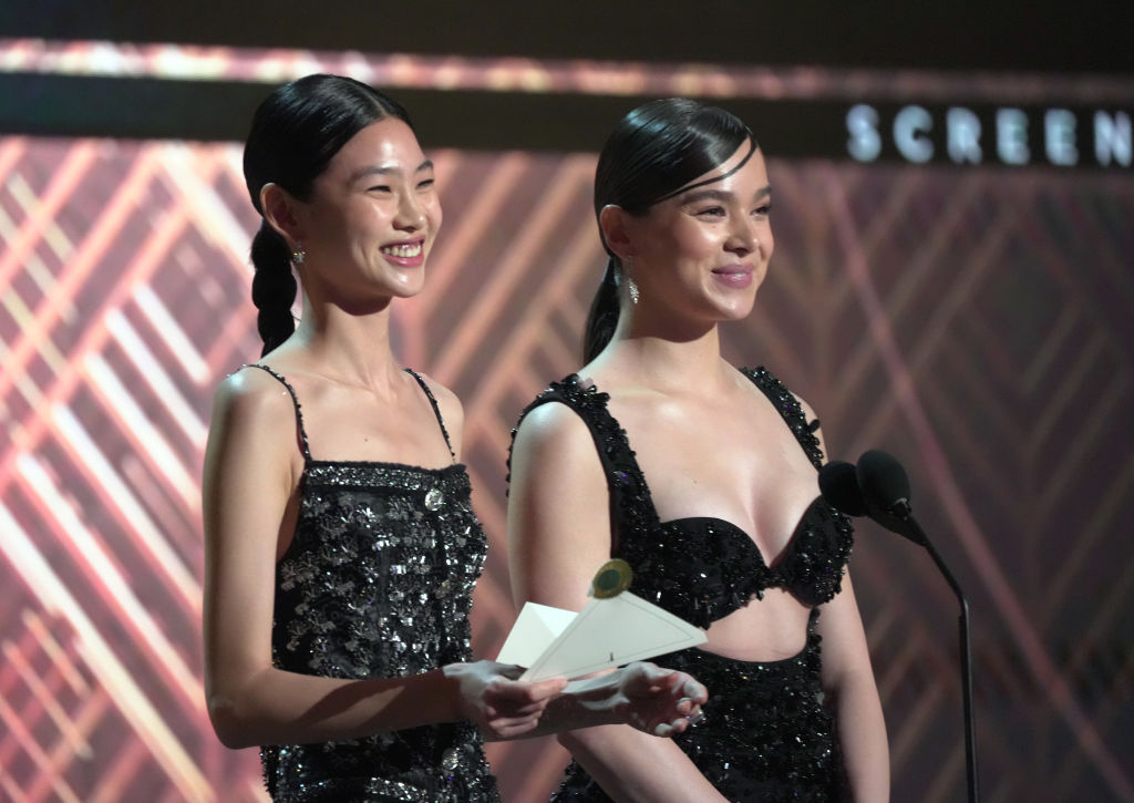 HoYeon Jung and Hailee Steinfeld speak onstage during the 28th Screen Actors Guild Awards at Barker Hangar on February 27, 2022 in Santa Monica, California