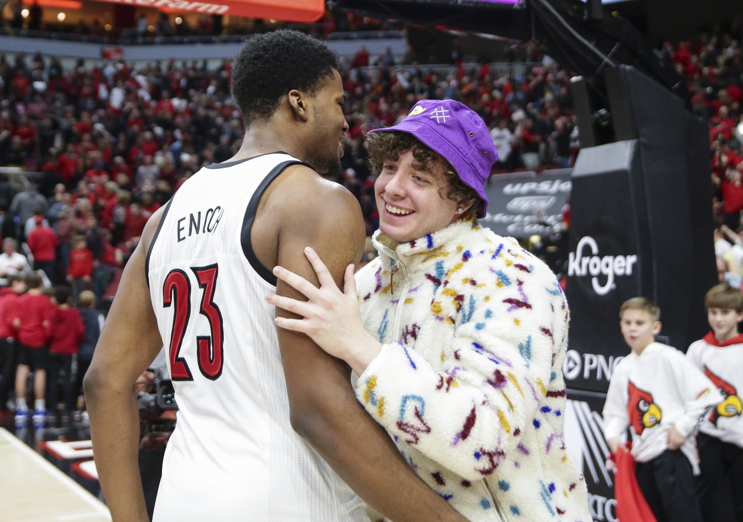 Steven Enoch #23 of the Louisville Cardinals celebrates with recording artist Jack Harlow after defeating the Virginia Cavaliers at KFC YUM! Center on February 08, 2020 in Louisville, Kentucky.
