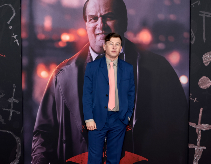 Barry Keoghan at The Batman premiere standing in front of colin farrell as the penguin poster
