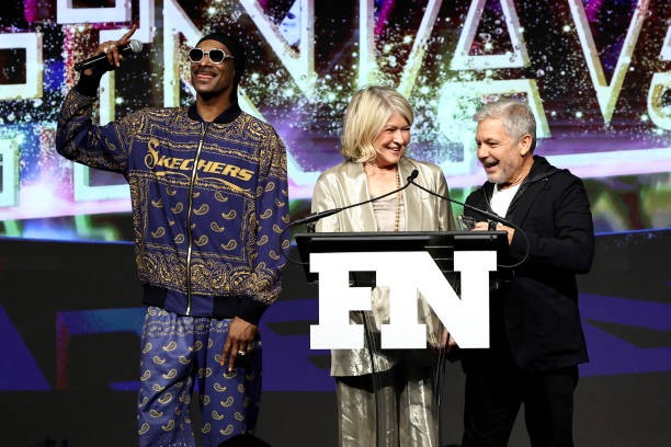 NEW YORK, NEW YORK - NOVEMBER 29: (L-R) Snoop Dogg and Martha Stewart present the Person of the Year Award to Michael Greenberg onstage during the 2023 Footwear News Achievement Awards at Cipriani South Street on November 29, 2023 in New York City. 