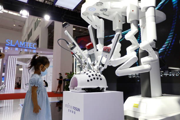 BEIJING, CHINA - SEPTEMBER 10: A child looks at a Da Vinci surgical robot at the booth of Intuitive Surgical - Fosun Medical Technology (Shanghai) Co., Ltd during 2021 World Robot Conference (WRC) at Beijing Etrong International Exhibition & Convention Center on September 10, 2021 in Beijing, China.
