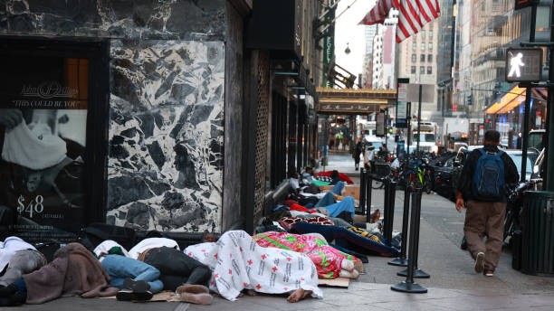 Migrants are seen sleeping outside the Roosevelt Hotel in Midtown Manhattan on July 31, 2023. Asylum seekers are camping outside the Roosevelt Hotel as the Manhattan relief center is at capacity. 