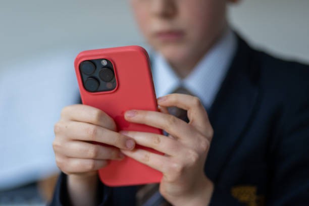 BATH, UNITED KINGDOM - FEBRUARY 25: In this photo illustration a a 12-year-old school boy looks at a iPhone screen on February 25, 2024 in Bath, England. 