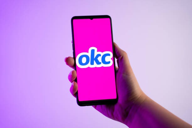 A person is holding a mobile phone with the OkCupid dating app logo on its screen, in Athens, Greece, on 31 January 2024. 