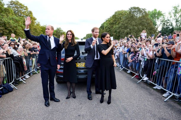 WINDSOR, ENGLAND - SEPTEMBER 10: Catherine, Princess of Wales, Prince William, Prince of Wales, Prince Harry, Duke of Sussex, and Meghan, Duchess of Sussex wave to crowd on the long Walk at Windsor Castle on September 10, 2022 in Windsor, England. Crowds have gathered and tributes left at the gates of Windsor Castle to Queen Elizabeth II, who died at Balmoral Castle on 8 September, 2022.