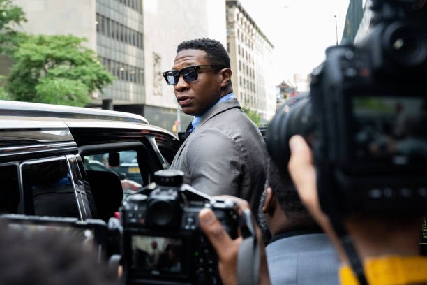 NEW YORK, NEW YORK - AUGUST 03: Jonathan Majors, looks backs at media while leaving Manhattan Criminal court after his pre trial hearing on August 03, 2023 in New York City. If convicted, Majors could face up to a year in jail over misdemeanor charges of assault and harassment. 