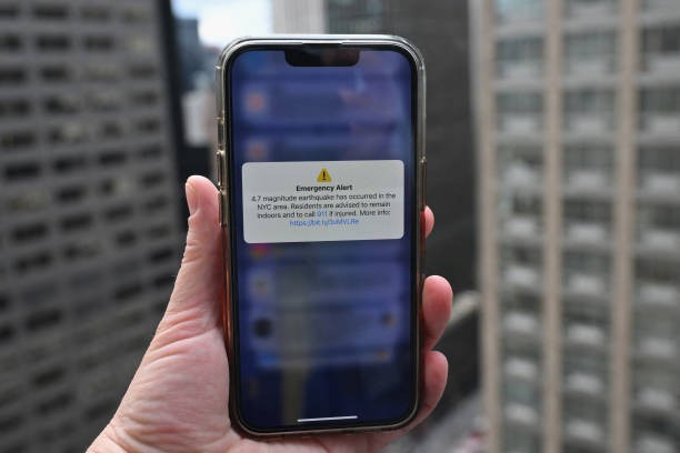 In this illustration, a phone shows an Emergency Alert message on April 5, 2024, warning of an earthquake in New York. New York City was shaken by a small earthquake on Friday with a 4.8 magnitude and an epicenter in neighboring New Jersey, according to the US Geological Survey (USGS). There were no initial reports of injuries or damage. In Brooklyn buildings shook, rattling cupboard doors and fixtures, an AFP correspondent reported. 