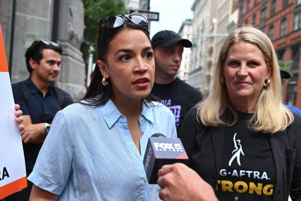 NEW YORK, NY - JULY 24: Alexandria Ocasio-Cortez walks the picket line in support of the SAG-AFTRA and WGA strike on July 24, 2023 in New York City. 