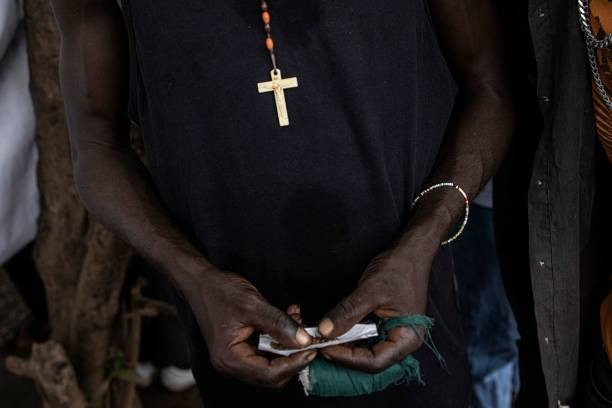 A man rolls his Kush in a drug den in Freetown on June 26, 2023. In recent years Kush, a mix of various chemicals and plants that mimic the natural properties found in cannabis, according to the National Drug Agency, is increasingly being used by youth in Sierra Leone. At only 25 US cents a dose, the drug is addicting users.