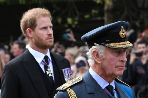 TOPSHOT - Britain's King Charles III and Britain's Prince Harry, Duke of Sussex walk behind the coffin of Queen Elizabeth II.