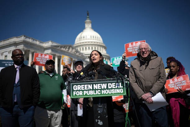 WASHINGTON, DC - MARCH 21: Rep. Alexandria Ocasio-Cortez (D-NY) (C) speaks during a press conference with Sen. Bernie Sanders (R) (I-VT) outside the U.S. Capitol March 21, 2024 in Washington, DC. Ocasio-Cortez and Sanders reintroduced the “Green New Deal for Public Housing Act” during the press conference. 