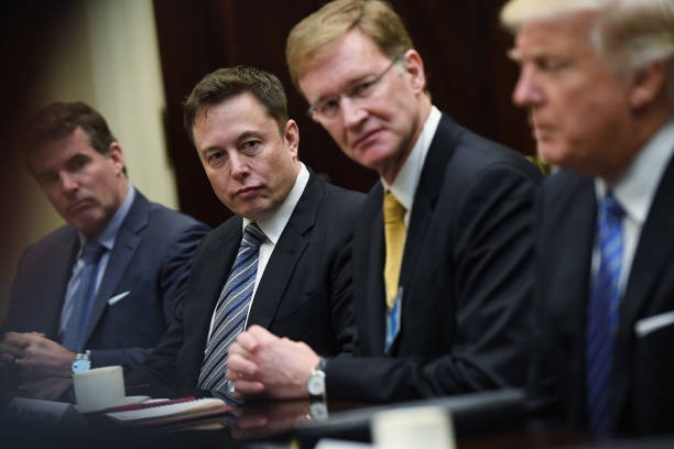 WASHINGTON, DC - JANUARY 23: Kevin Plank of Under Armour, left to center, Elon Musk of SpaceX and Wendell P. Weeks of Corning listen to President Donald Trump during a meeting with business leaders in the Roosevelt Room of the White House on Monday January 23, 2017.