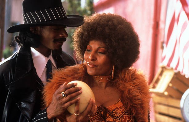 Snoop Dogg and Pam Grier feeling a melon in a scene from the film 'Bones', 2000.