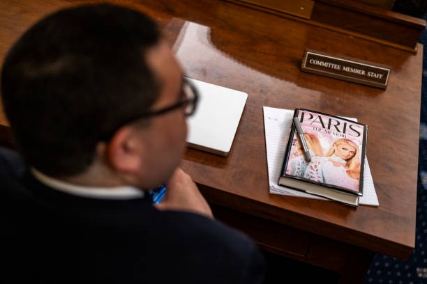 WASHINGTON, DC - JUNE 26: A committee staff member brought a copy of Actress and child welfare advocate Paris Hilton's memoir to the House Committee on Ways and Means hearing on 