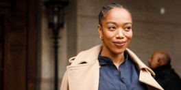 Naomi Ackie wearing Stella McCartney trench coat, navy shirt green stilettos and baby blue leather bag outside Stella McCartney during Paris Fashion Week Womenswear Fall/Winter 2020/2021 Day Eight on March 02, 2020 in Paris, France.